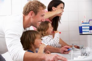 Photo of Family in bathroom brushing teeth.